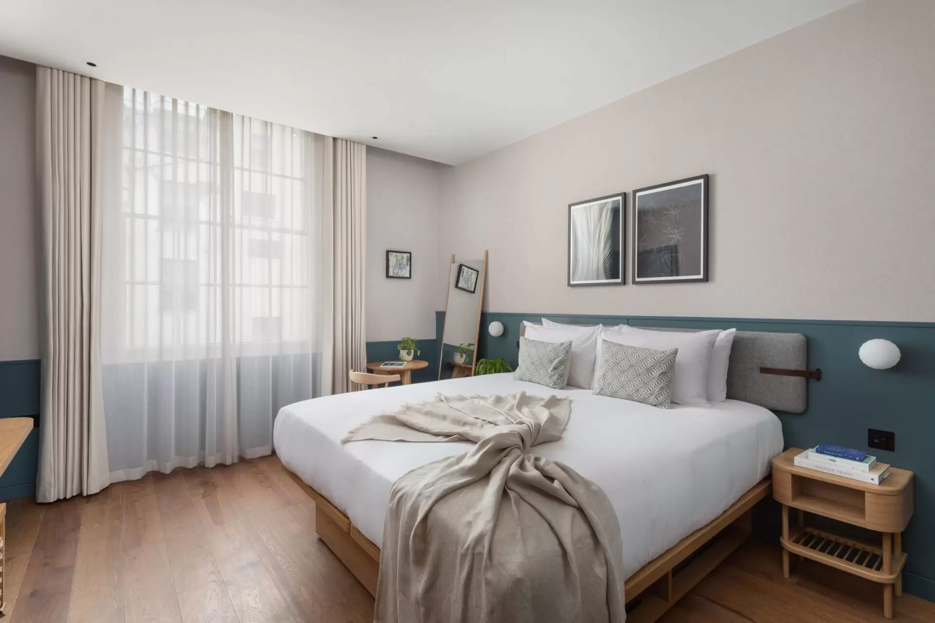hotel bedroom with half blue walls, with wooden furniture