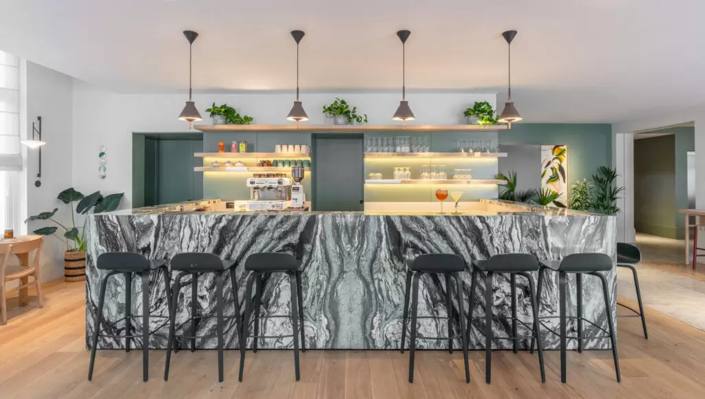 coffee and bar area with green and grey marble and green walls