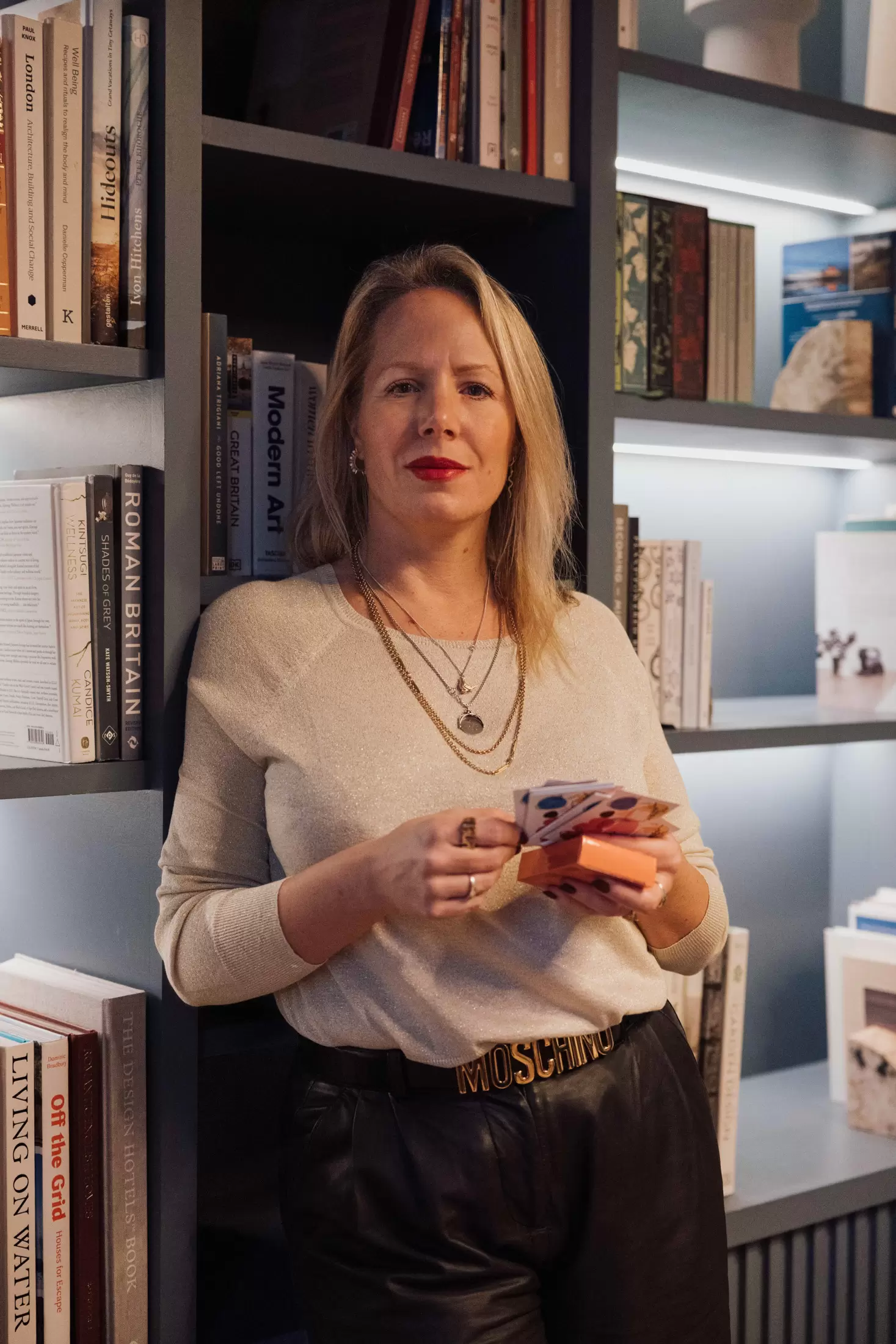 woman standing in library holding cards