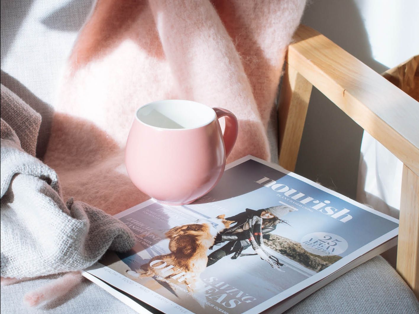 pink coffee mug with pink scarf with nourish magazine